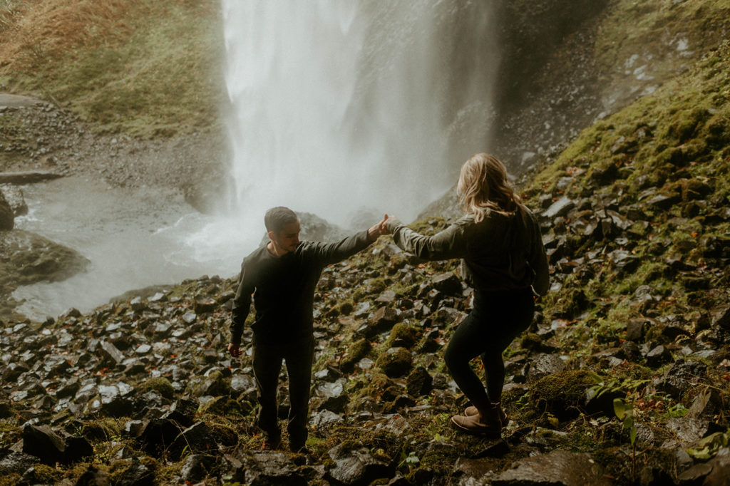 Couples photos holding hands at waterfall in Oregon