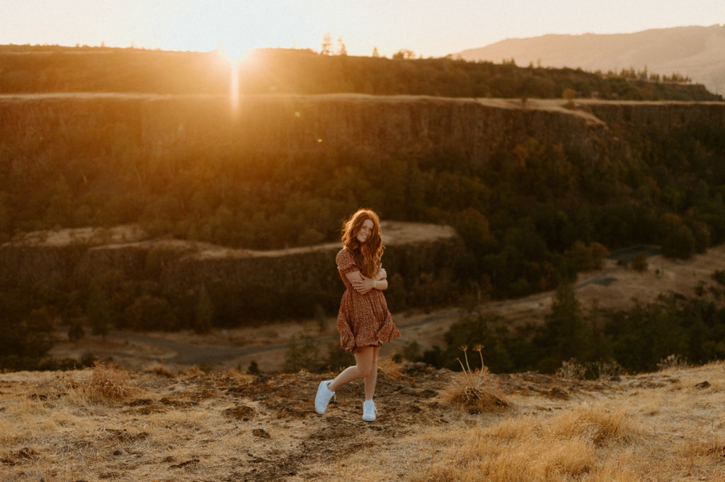 Senior standing on cliffs edge for photoshoot in Oregon