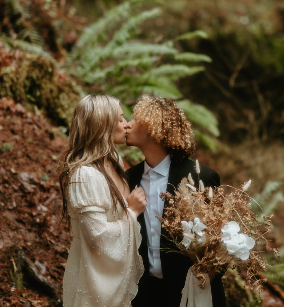 Bride and groom kissing with Dried floral bouquet 
