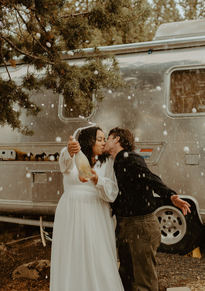 Smith Rock State Park, Oregon elopement with Airstream. Bride and groom champagne spray