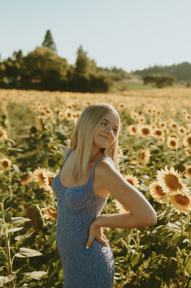 senior photo in sunflower field