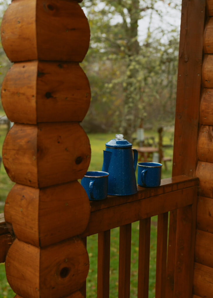 coffee pot sitting on the railing of a cabin