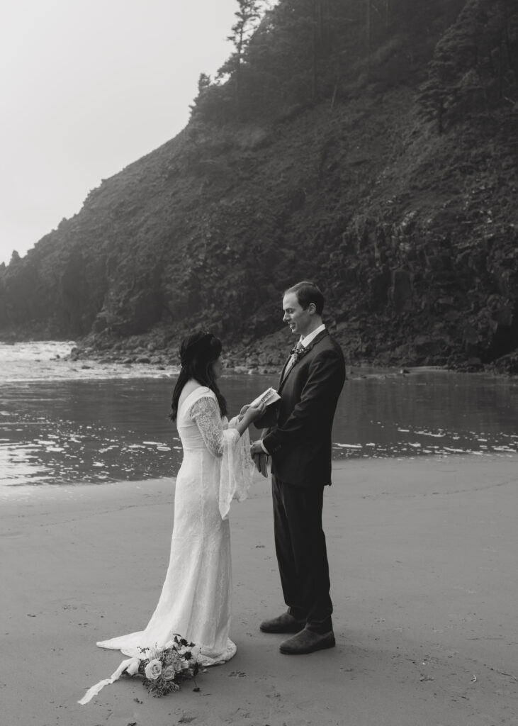 A black and white photo of bride and groom exchange vows at Indian Beach in Cannon Beach