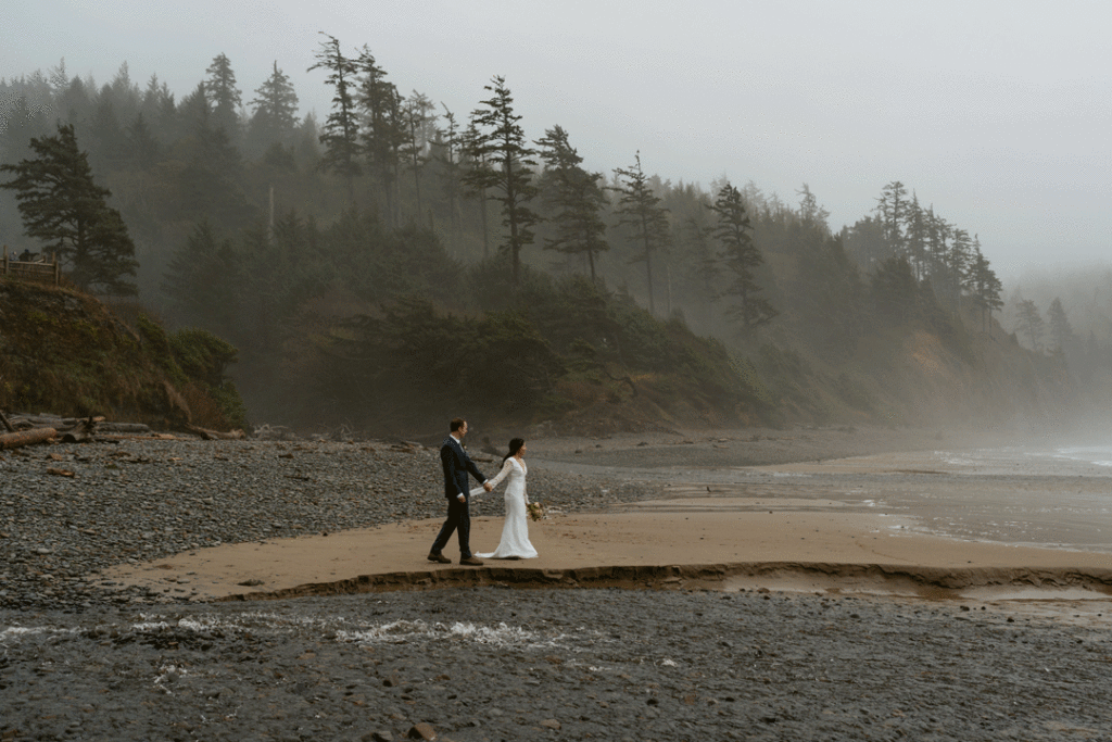 bride and groom walking on rocky beach in Cannon Beach Oregon for their dreamy elopement