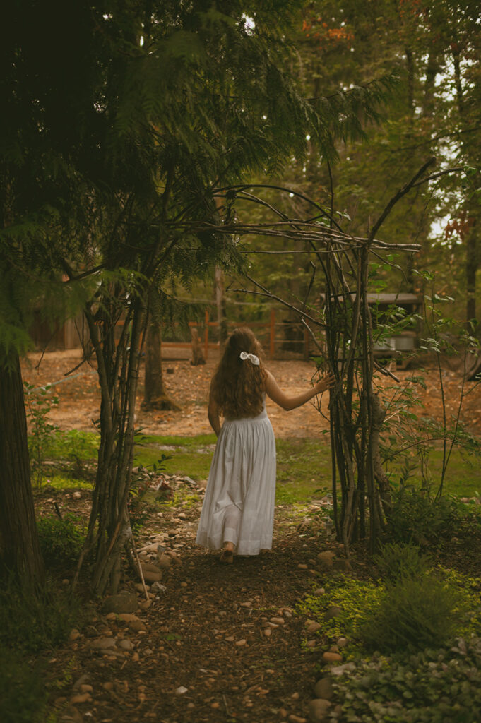 Young woman in white dress walking through forest