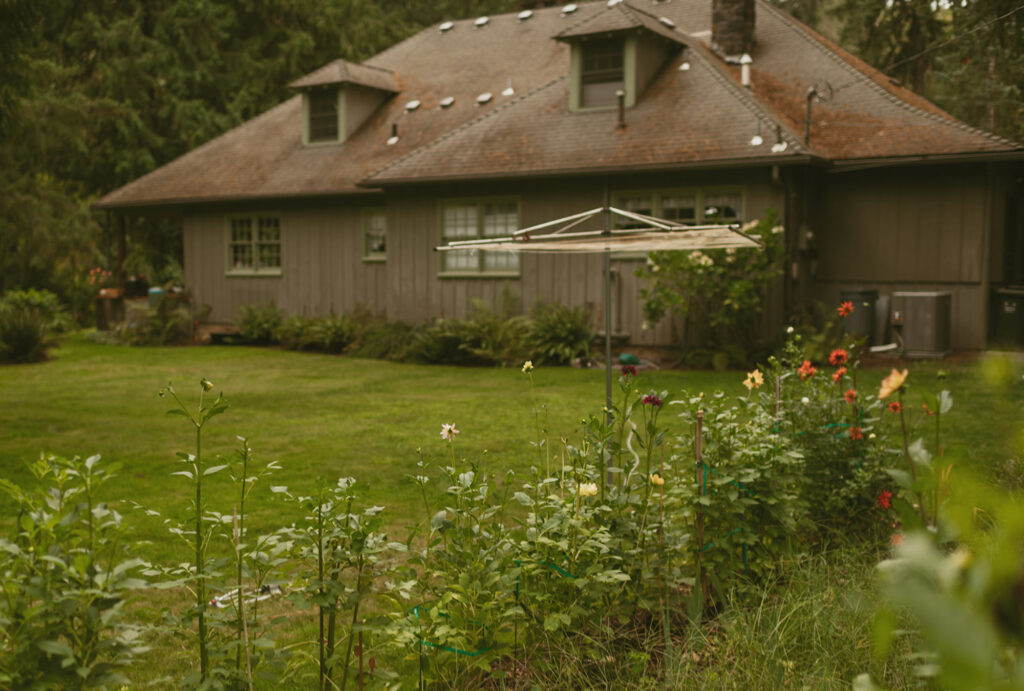 A rustic house with a flower garden in the foreground