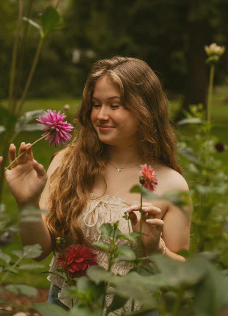 Young woman smiling while holding flowers for her cottage core aesthetic photo session in Oregon