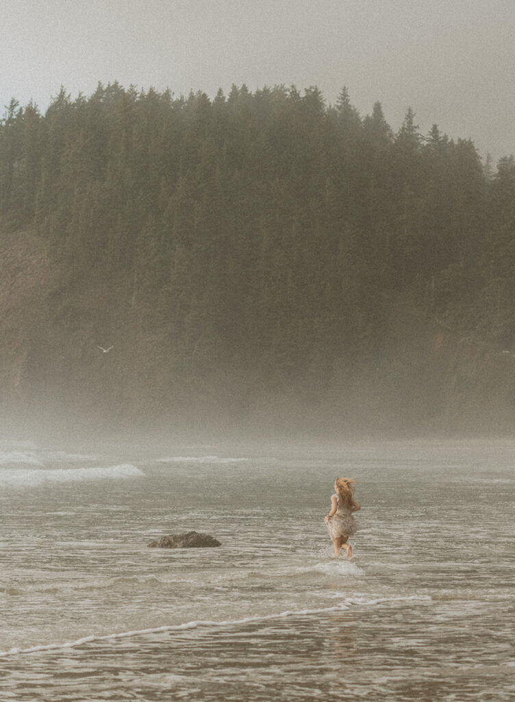 girl running through ocean on the Oregon coast