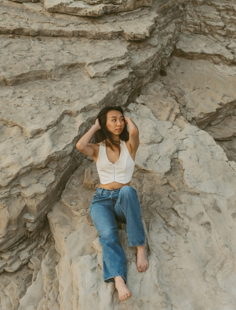 girl sitting on rocks at the Oregon coast