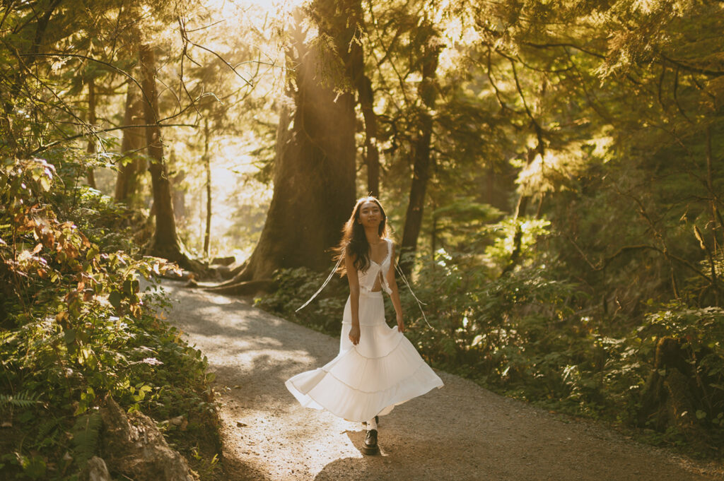 girl in white dress twirling on trail