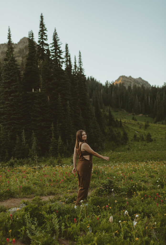 girl in brown overalls standing in forest in the Pacific northwest