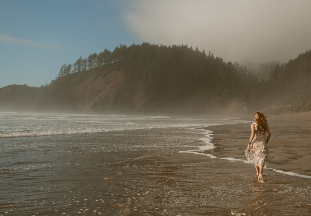 girl in white dress running on a beach at the Oregon coast