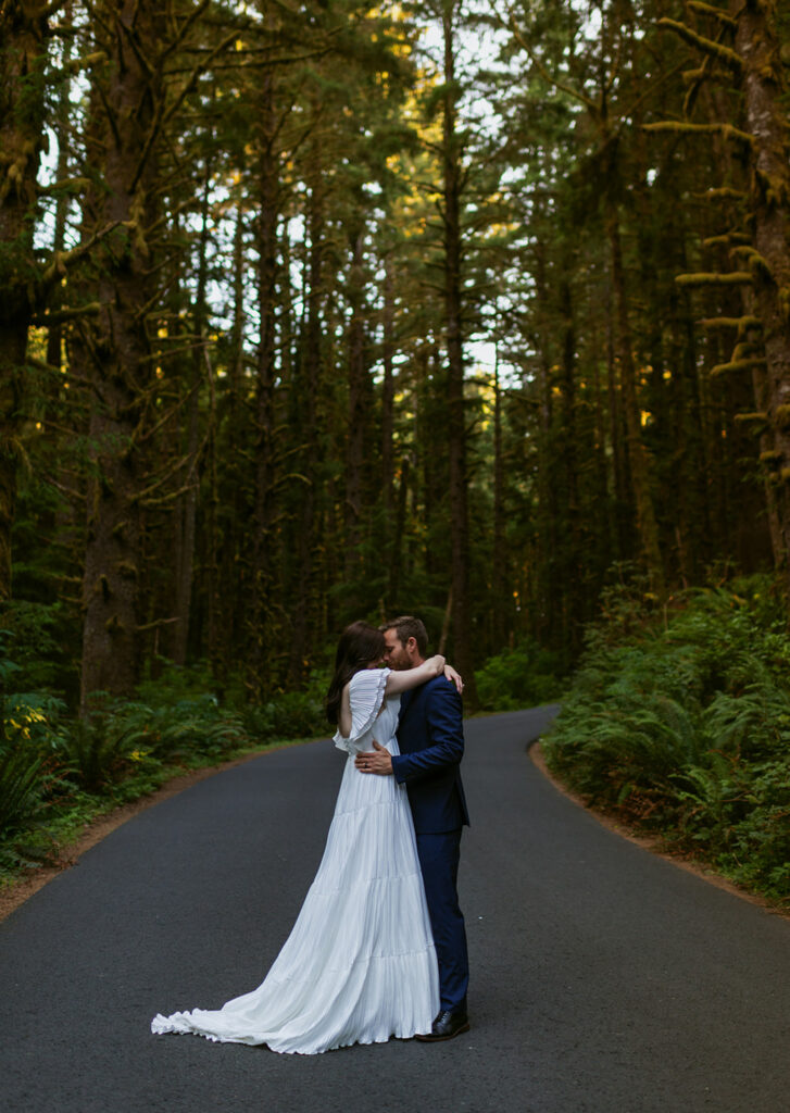bride and groom standing on paved road at Ecola State Park