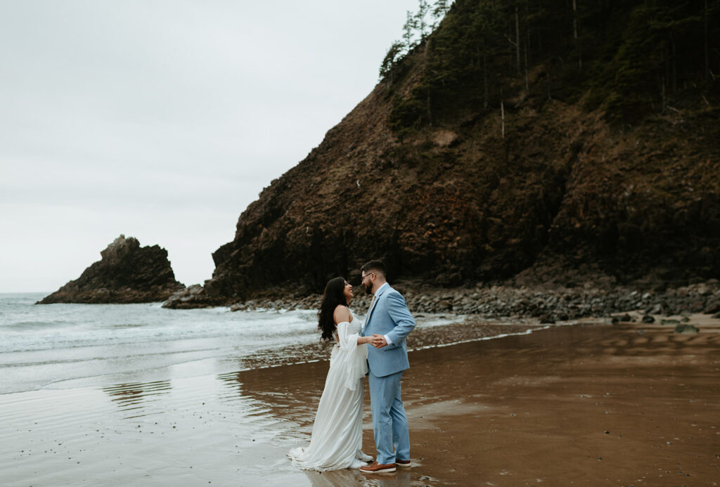 intimate wedding at Ecola state park with couple standing on the beach