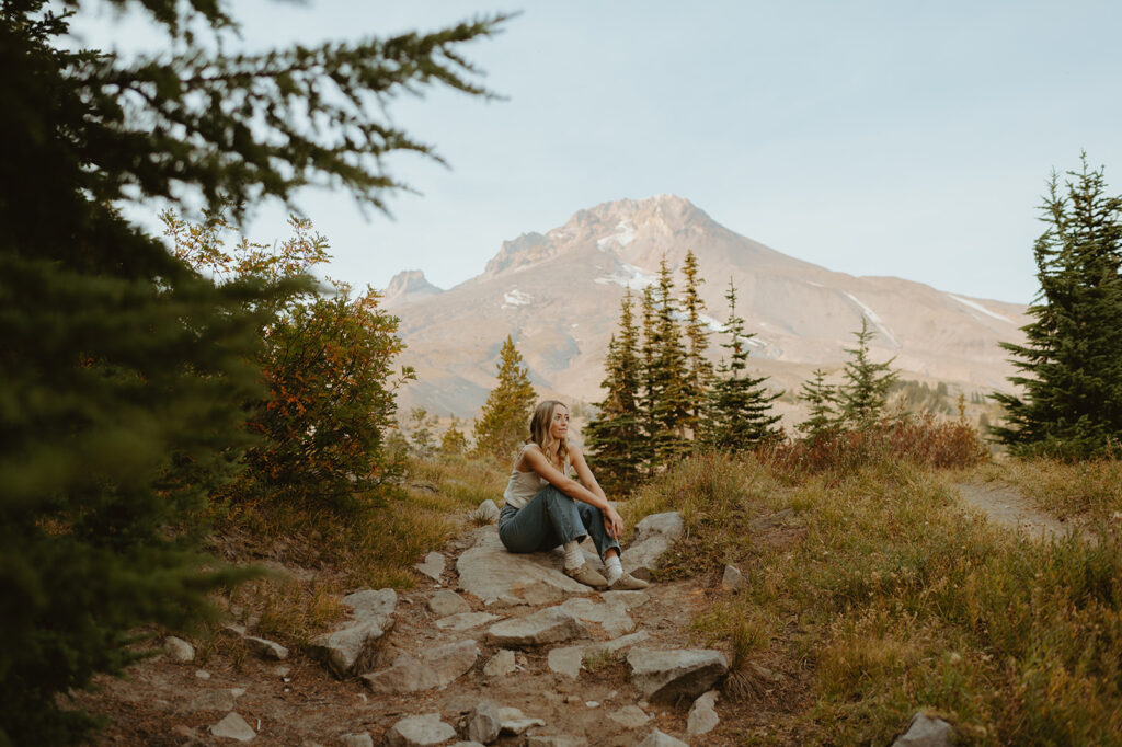 Young woman sitting on a rocky path for her senior session in Oregon