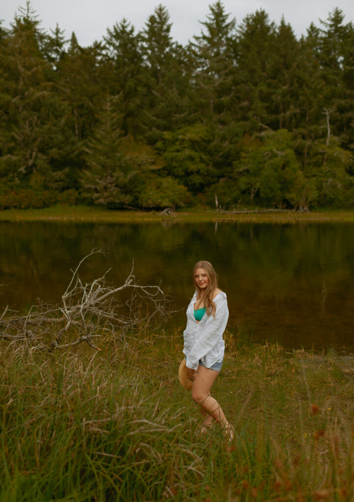 girl standing in tall grass next to lake on Oregon coast
