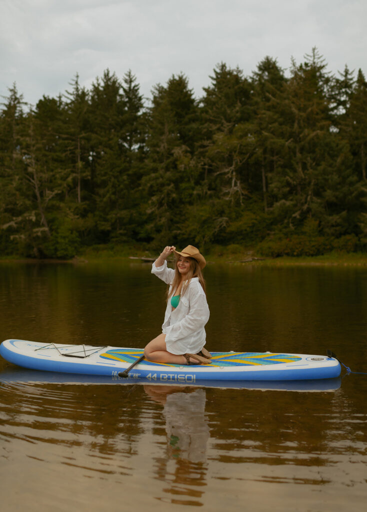 girl sitting on paddle board on a lake