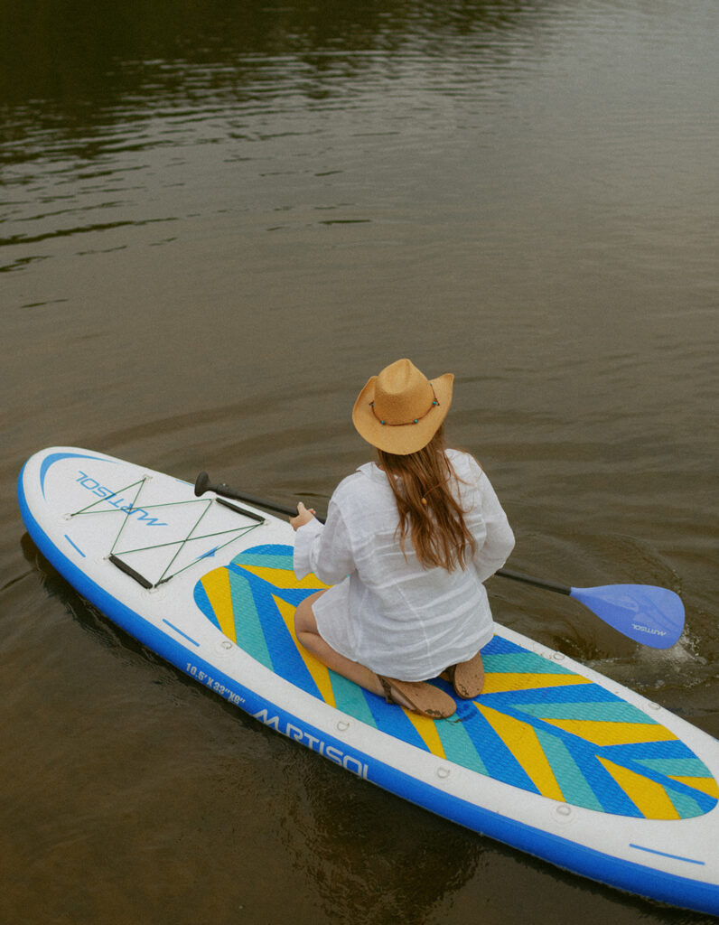 girl in white shirt paddle boarding on a lake at the Oregon coast