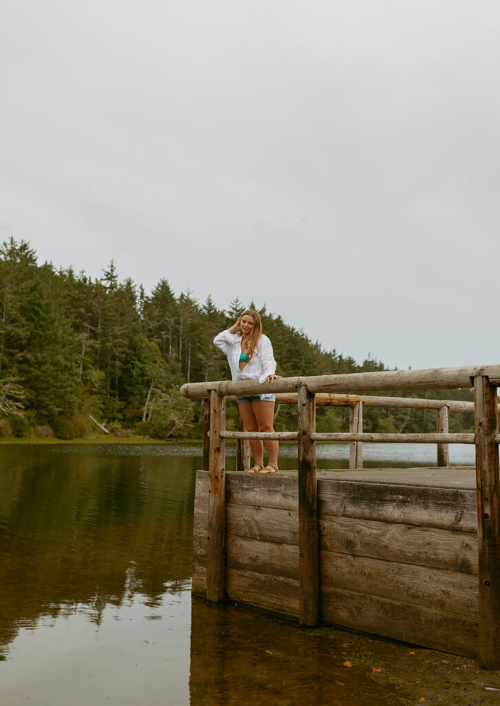girl leaning against fence at lake on Oregon coast