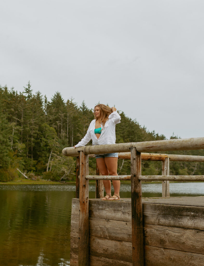 girl leaning against the fencing on a dock at a lake in Oregon