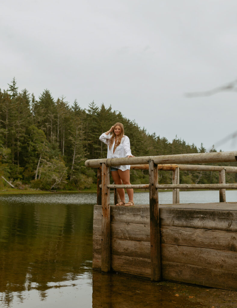 girl leaning against the fencing on a dock at a lake in Oregon