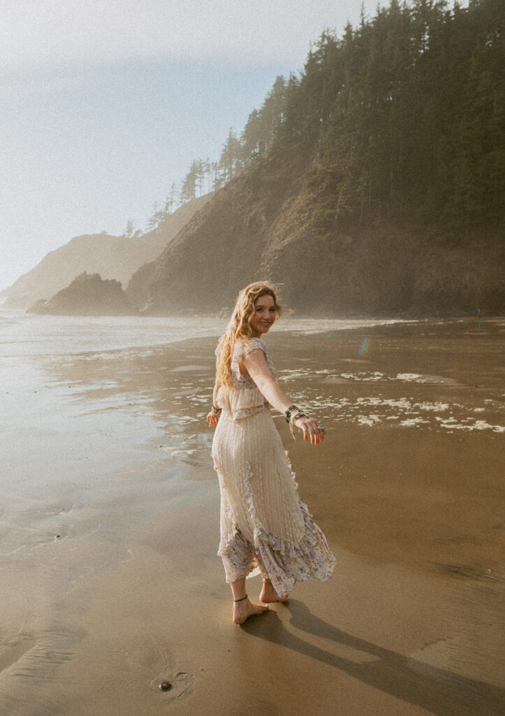 girl twirling on the beach in dress at the Oregon coast