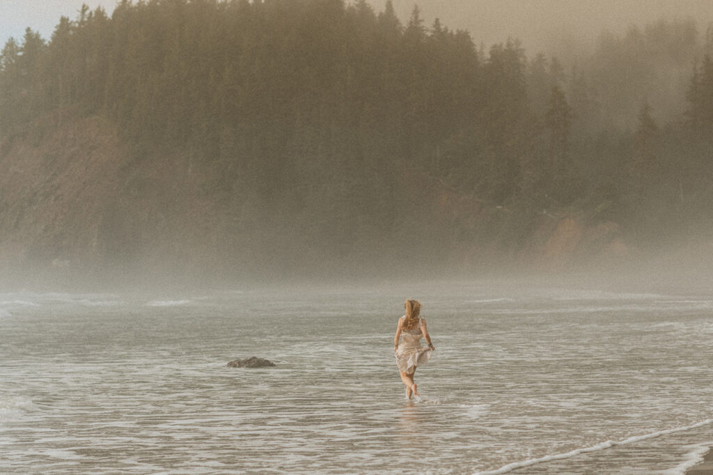 girl running through ocean waves at the Oregon coast