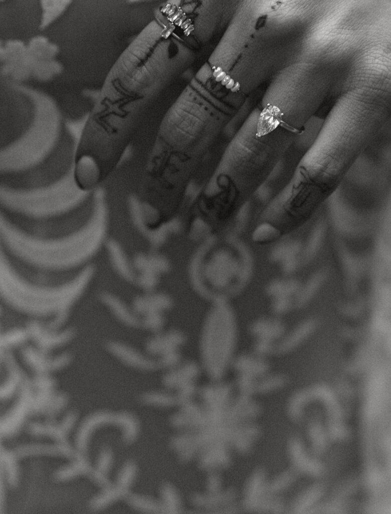 black and white close-up the bride's hand with various rings and detailed henna designs on her fingers