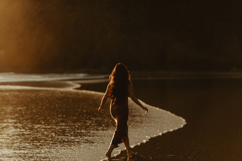 Woman with long hair walks barefoot along the shoreline