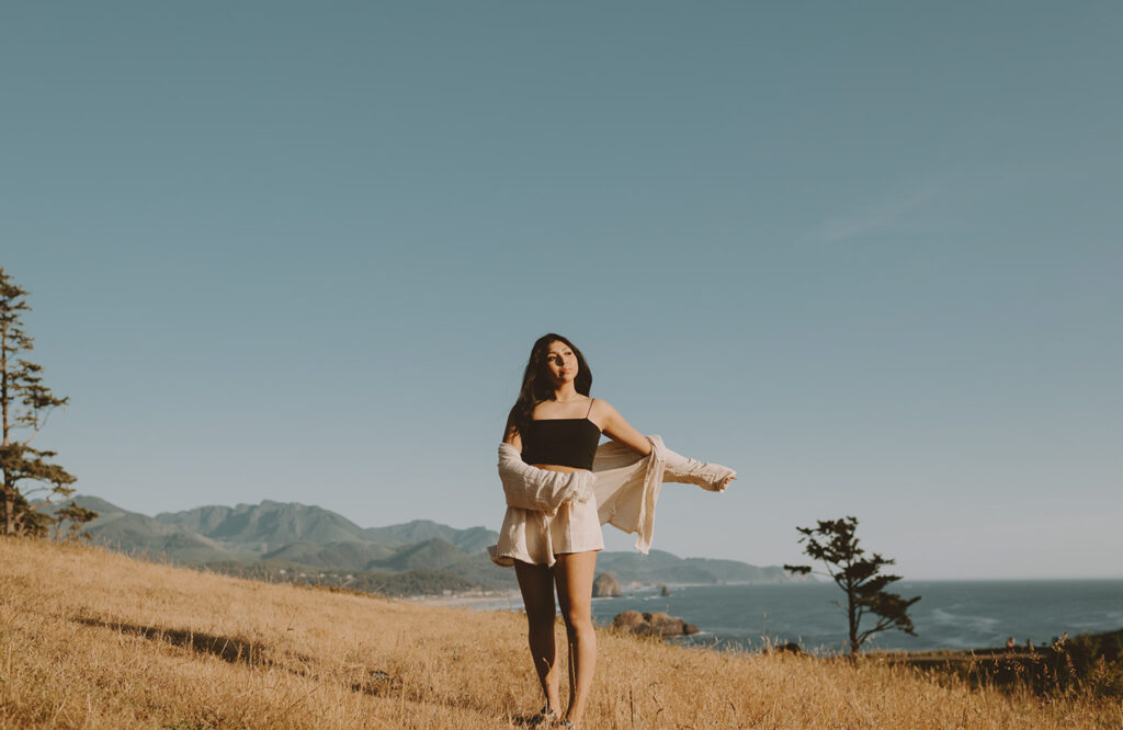 Woman walking towards the camera with mountains in the background for her senior session