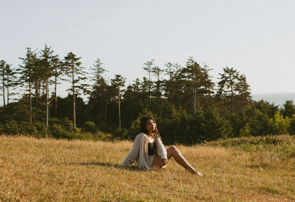 A woman sitting in a grassy field
