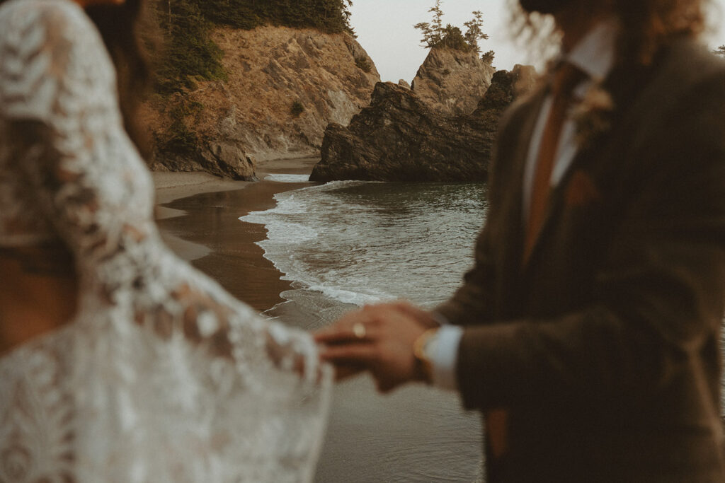 Romantic elopement by the Oregon coast with the couple standing on a rocky shoreline