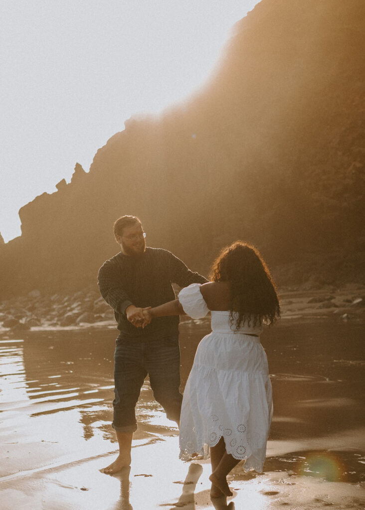 Couple dancing on a sunlit beach in Oregon