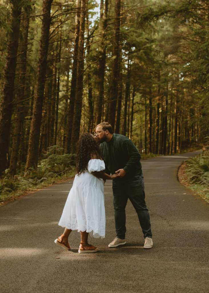 Couple kissing on a forested road for an Engagement Session in Oregon