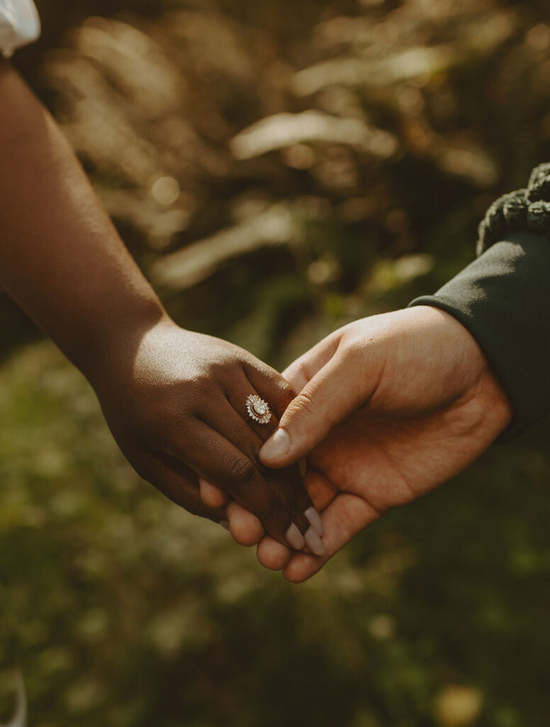 Close-up of hands holding with an engagement ring