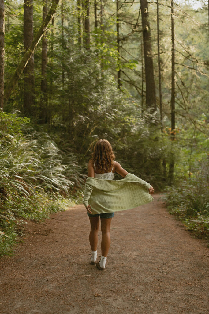 Woman walking joyfully on a forest path