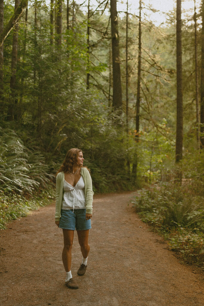 Woman walking on a forest trail, looking back