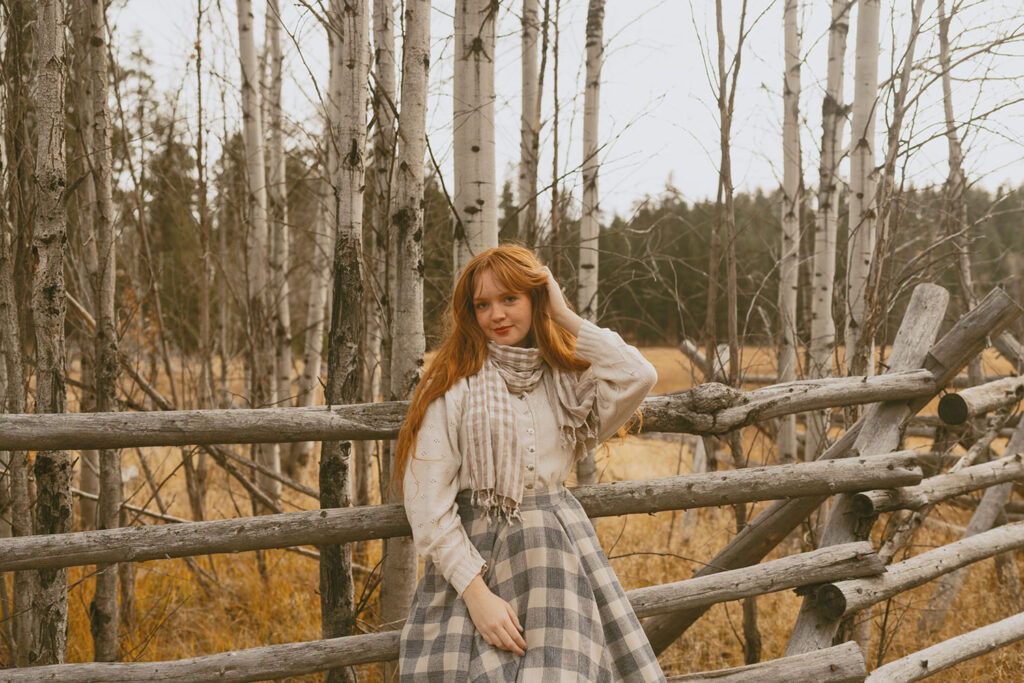 Senior girl leaning on a rustic wooden fence, embracing the Black Butte scenery