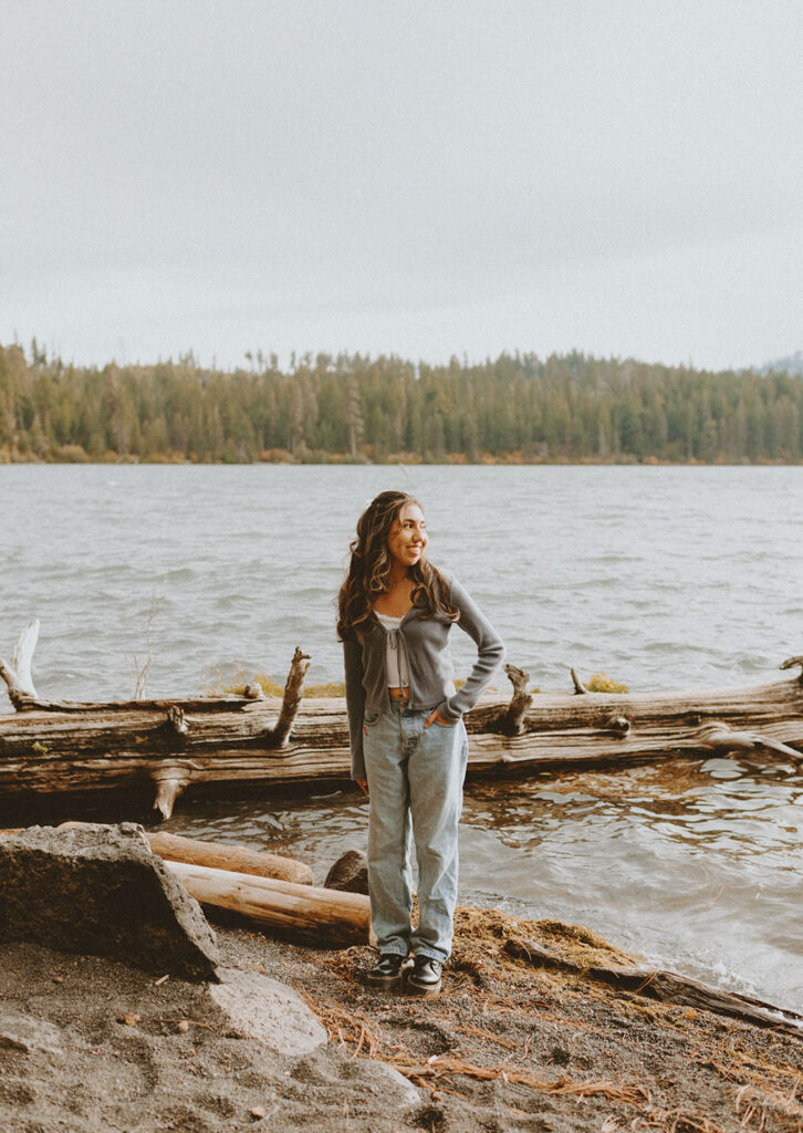 Senior girl standing by the lake for a photo session by a senior photographer in Bend