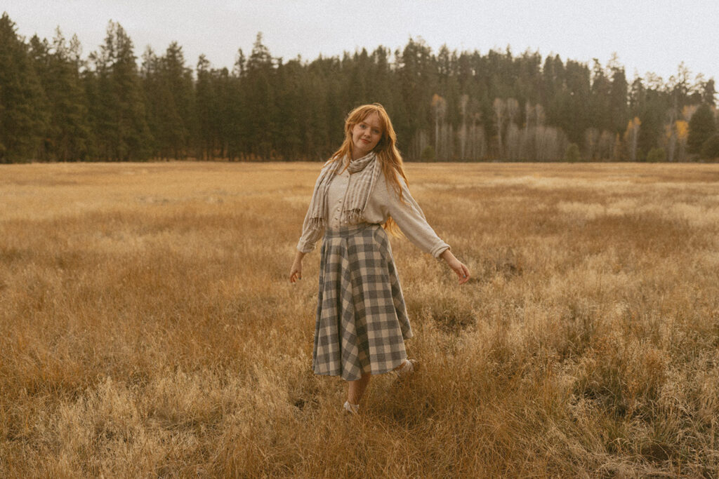 Senior girl walking through the golden grass, embracing the rustic landscape