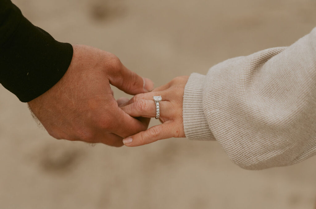 Callie and Nolan hold hands, showcasing her engagement ring