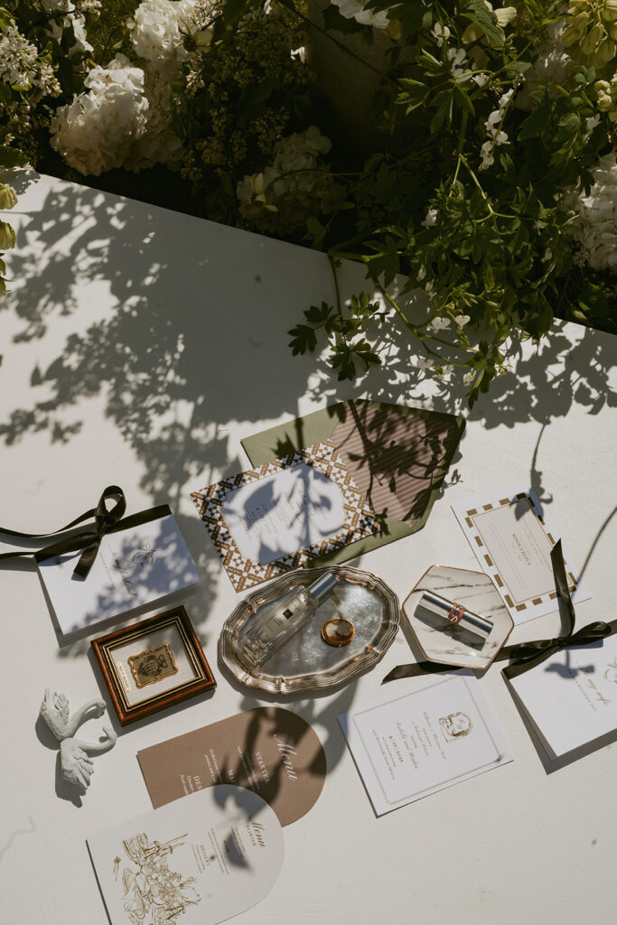 A white table topped with a variety of objects and flowers.