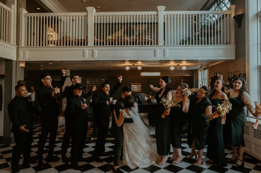 A bride and groom are posing for a picture with their wedding party.