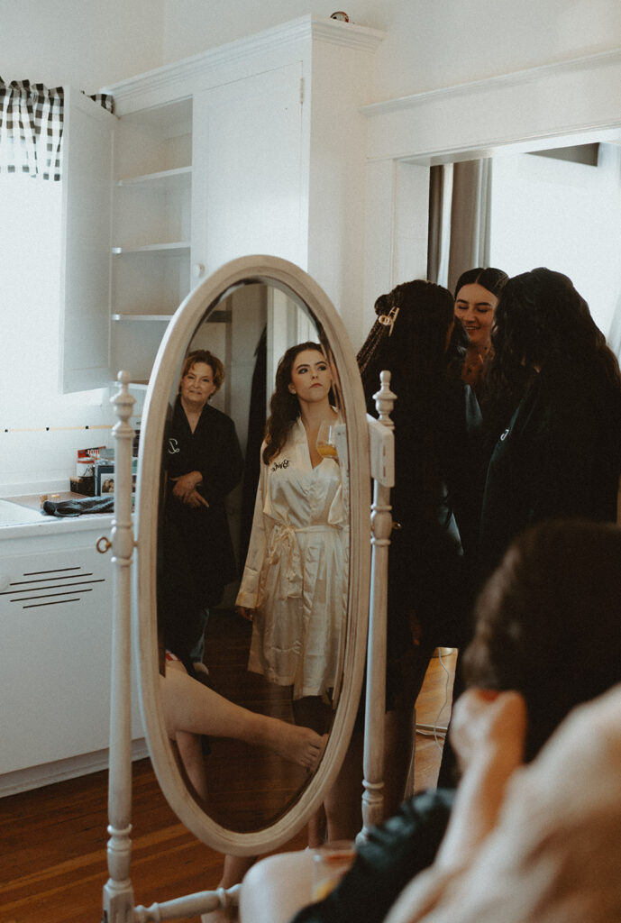 A group of people are looking at themselves in a mirror.