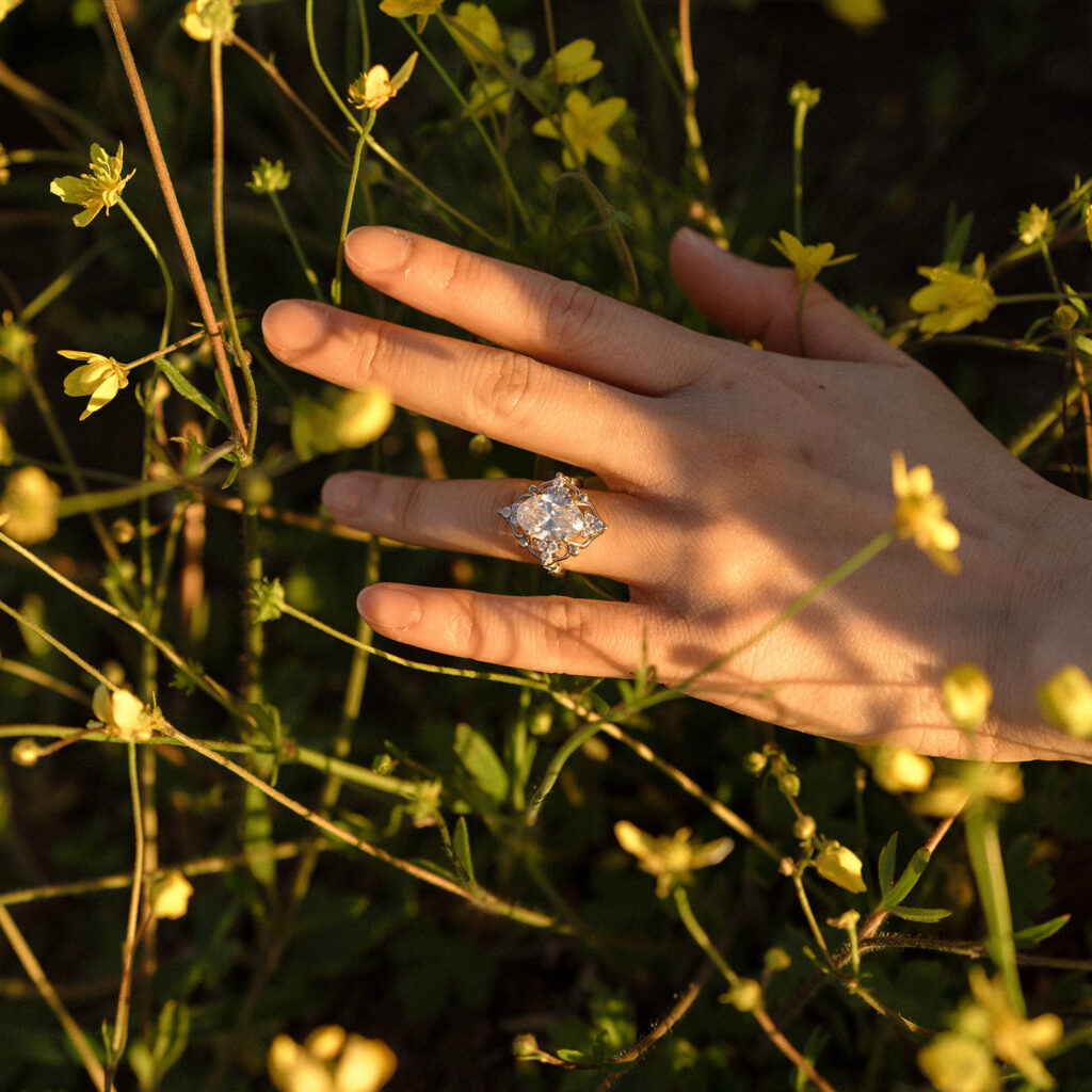 Close-up of engagement ring among wild yellow flowers