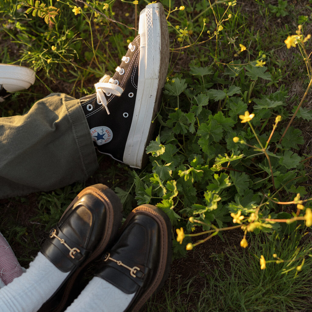 Shoes of the couple resting in a field with yellow blooms