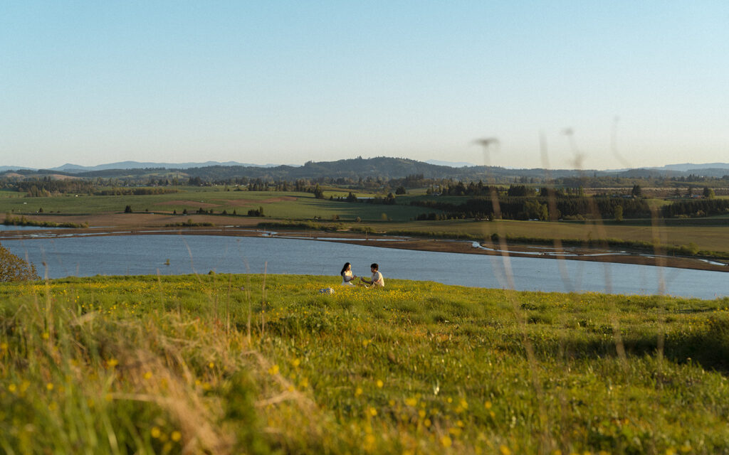 Couple having a picnic on a hilltop overlooking the lake