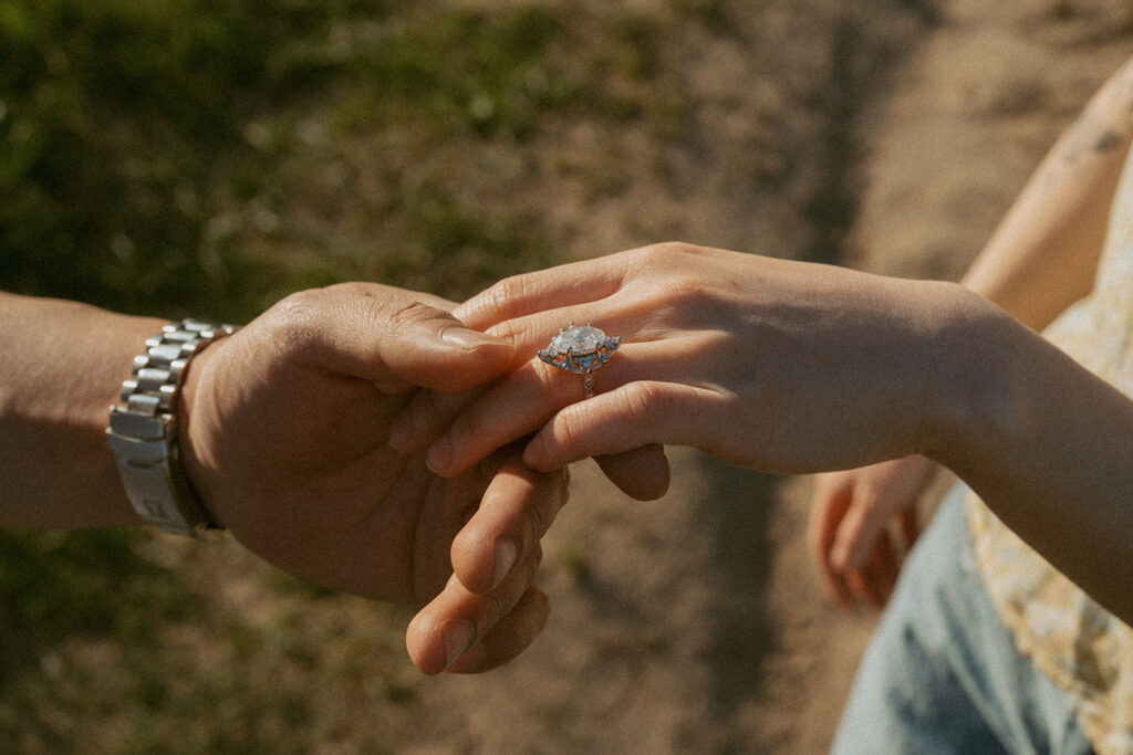 couple holding hands showcasing the engagement ring