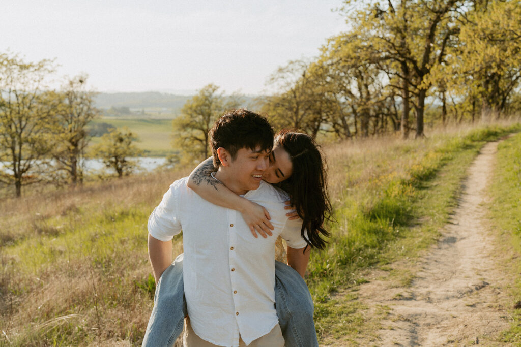 Woman hugging her partner from behind on a scenic trail