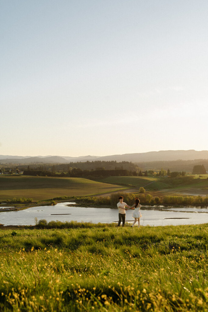 Couple dancing together on a hill overlooking the lake